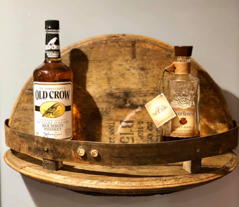 Barrel lid wall shelf display with bourbon bottles
